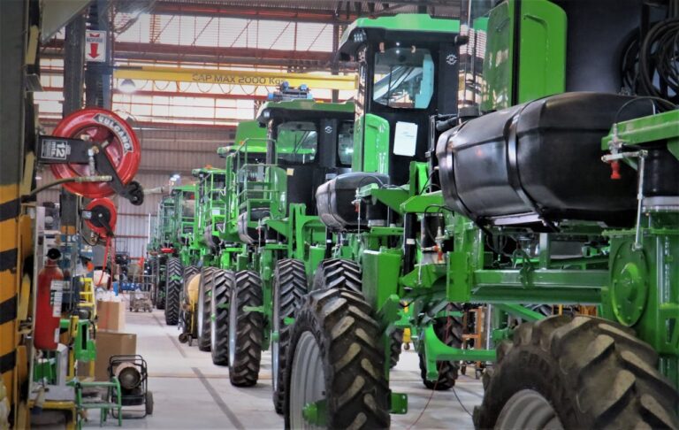 Line of green agricultural machines inside a warehouse in Cascavel, Brazil.