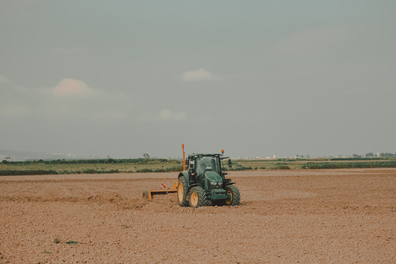 A tractor working on a vast field in the rural landscapes of Mersin, Türkiye.